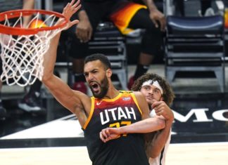 Utah Jazz center Rudy Gobert (27) and Brooklyn Nets guard Tyler Johnson, rear, work for position near the basket during the first half of an NBA basketball game Wednesday, March 24, 2021, in Salt Lake City. (AP Photo/Rick Bowmer)