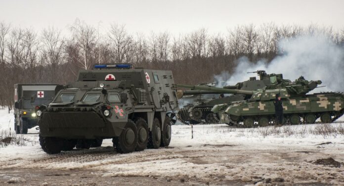 Ukrainian armored vehicles drive during military drills close to Kharkiv, Ukraine, Thursday, Feb. 10, 2022. Britain\'s top diplomat has urged Russia to take the path of diplomacy even as thousands of Russian troops engaged in sweeping maneuvers in Belarus as part of a military buildup near Ukraine. (AP Photo/Andrew Marienko)