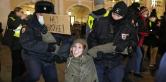 Police officers detain a demonstrator holding a sign reading \'No war!\' during an action against Russia\'s attack on Ukraine in St. Petersburg, Russia, Thursday, Feb. 24, 2022. Hundreds of people gathered in the center of Moscow on Thursday, protesting against Russia\'s attack on Ukraine. Many of the demonstrators were detained. Similar protests took place in other Russian cities, and activists were also arrested. (AP Photo/Dmitri Lovetsky)