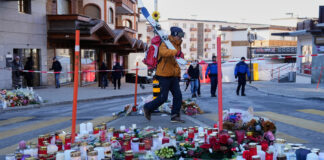 A skier passes candles near the sealed off Le Constellation bar in Crans-Montana, Swiss Alps, Switzerland, Saturday, Jan. 3, 2026, where a devastating fire left dead and injured during the New Year's celebrations. (AP Photo/Baz Ratner)