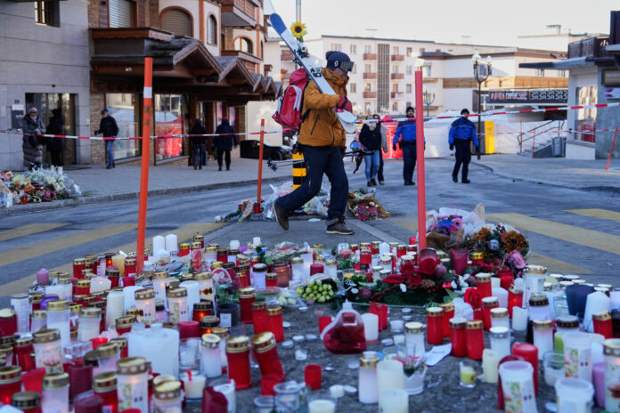 Crans-Montana, i giorni dopo la tragedia A skier passes candles near the sealed off Le Constellation bar in Crans-Montana, Swiss Alps, Switzerland, Saturday, Jan. 3, 2026, where a devastating fire left dead and injured during the New Year's celebrations. (AP Photo/Baz Ratner)
