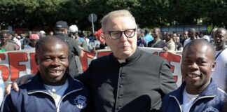 Raffaele Nogaro con due migranti