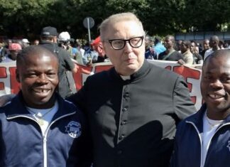 Raffaele Nogaro con due migranti