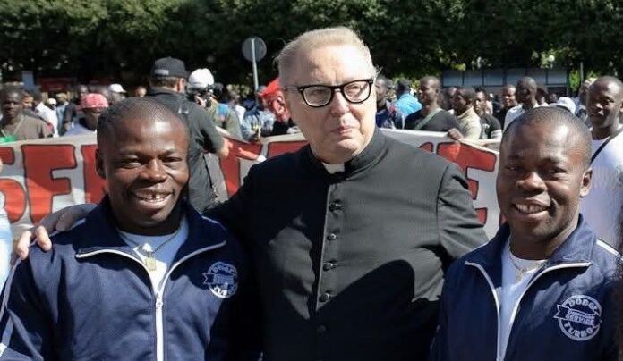 Raffaele Nogaro con due migranti