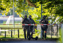 Tragedia al rave di Aarau, caccia al killer di Maria Spinelli. Un’ombra in fuga verso la Germania Armed police officers patrol near the Schachen horse racing track in Aarau following a shooting during a rave event near Aarau, Switzerland, Sunday, Aug. 30, 2026. (Michael Buholzer/Keystone via AP)