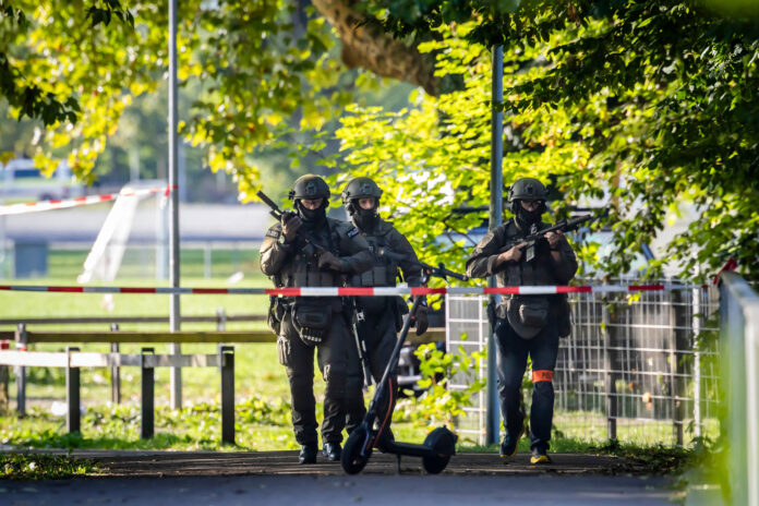 Armed police officers patrol near the Schachen horse racing track in Aarau following a shooting during a rave event near Aarau, Switzerland, Sunday, Aug. 30, 2026. (Michael Buholzer/Keystone via AP)